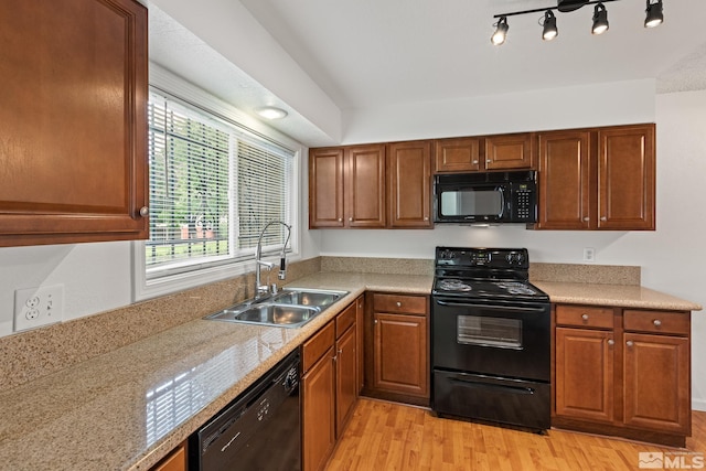 kitchen with light hardwood / wood-style flooring, black appliances, and sink