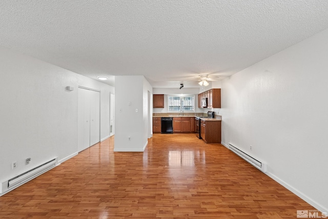 unfurnished living room with a textured ceiling, baseboard heating, and light hardwood / wood-style floors