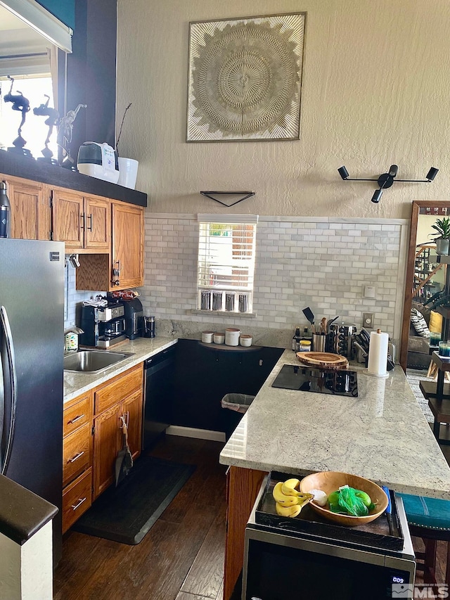 kitchen with backsplash, black appliances, a center island, dark hardwood / wood-style floors, and sink