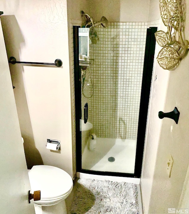 bathroom with toilet and tiled shower