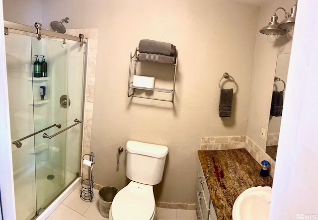 bathroom featuring tile patterned flooring, vanity, toilet, and a shower with shower door