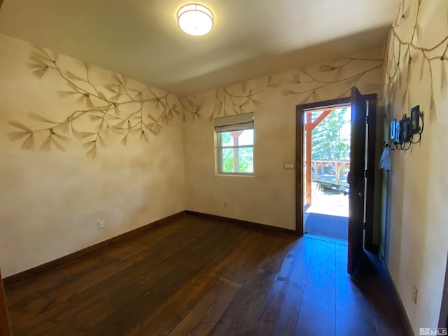 unfurnished room with dark wood-type flooring