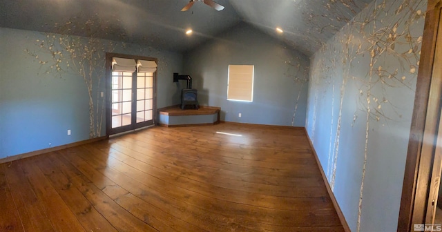 interior space featuring a wood stove, lofted ceiling, ceiling fan, and hardwood / wood-style floors