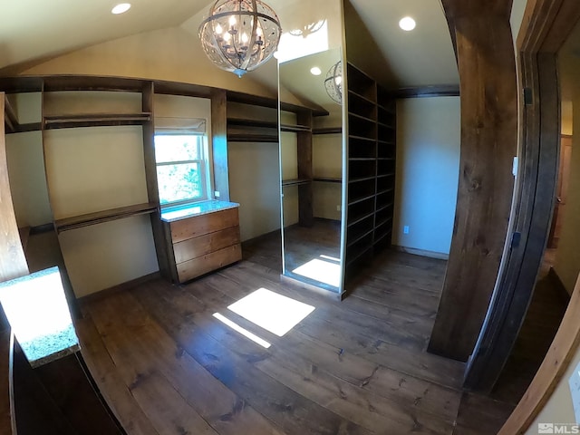 spacious closet featuring a notable chandelier, lofted ceiling, and dark wood-type flooring