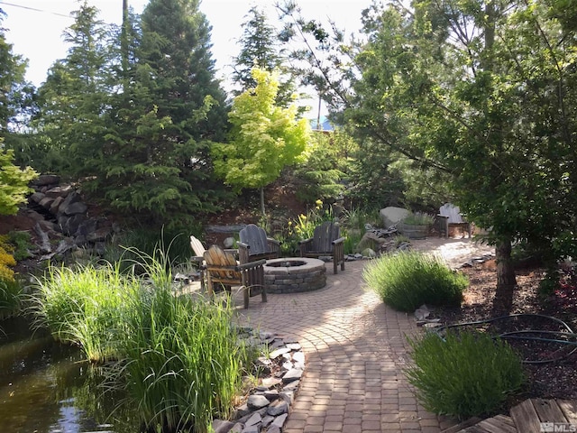 view of patio with a water view and an outdoor fire pit