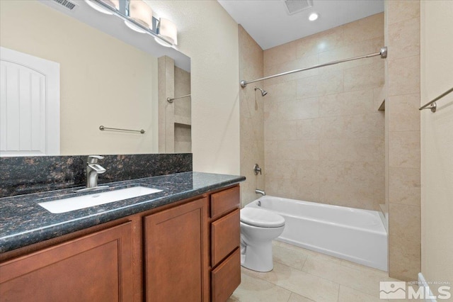 full bathroom featuring tile patterned flooring, tiled shower / bath, vanity, and toilet