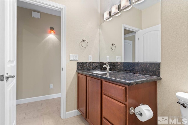 bathroom with tile patterned flooring, vanity, and toilet