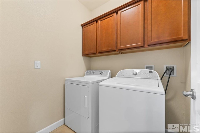 washroom featuring washer and clothes dryer and cabinets