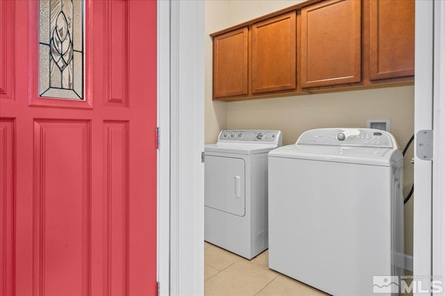 laundry area featuring light tile patterned flooring, independent washer and dryer, and cabinets