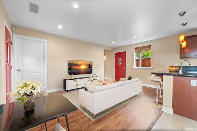 living room featuring light hardwood / wood-style flooring and sink