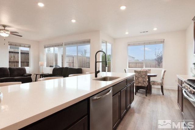 kitchen with ceiling fan, dark brown cabinetry, sink, light hardwood / wood-style flooring, and stainless steel appliances