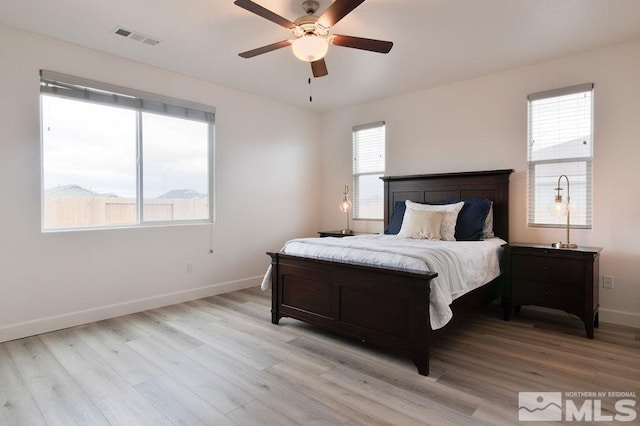 bedroom with light hardwood / wood-style floors, multiple windows, and ceiling fan