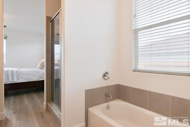 bathroom with plus walk in shower and hardwood / wood-style flooring