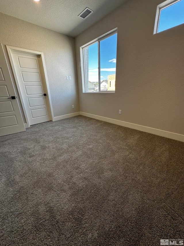 unfurnished bedroom featuring a textured ceiling and carpet flooring