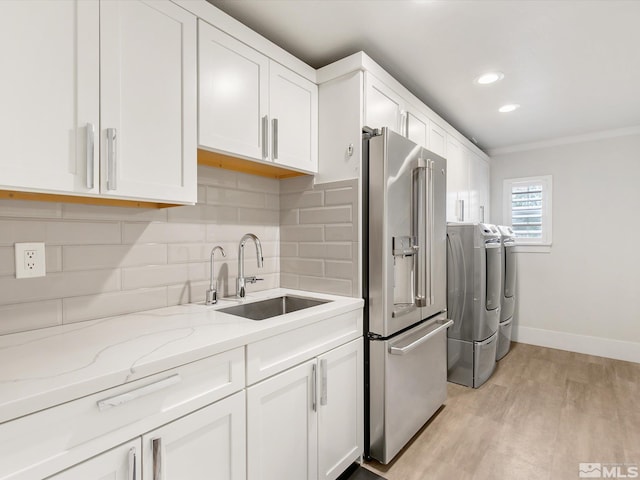 kitchen featuring light wood-type flooring, light stone counters, white cabinetry, separate washer and dryer, and high end fridge