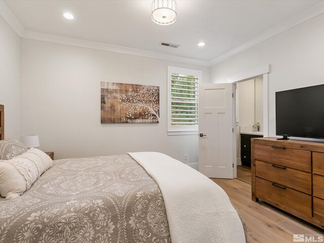 bedroom featuring light wood-type flooring, connected bathroom, and crown molding