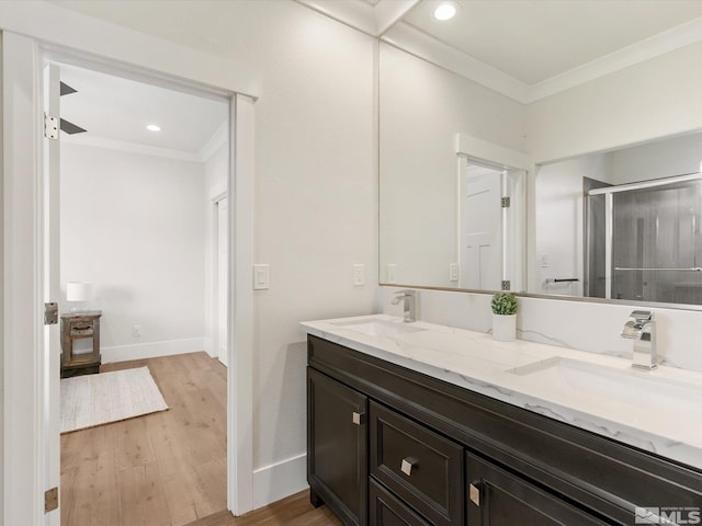 bathroom with wood-type flooring, vanity, crown molding, and an enclosed shower