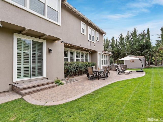 rear view of house featuring a lawn and a patio area