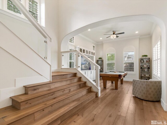 staircase featuring wood-type flooring, ornamental molding, pool table, and ceiling fan