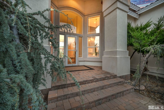 exterior entry at dusk with a patio area