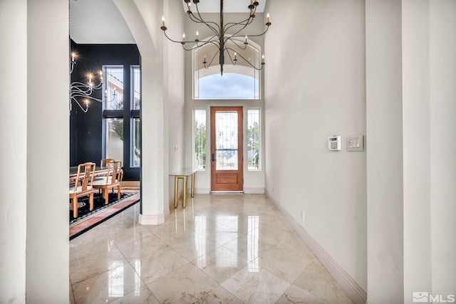 entryway with an inviting chandelier and a towering ceiling