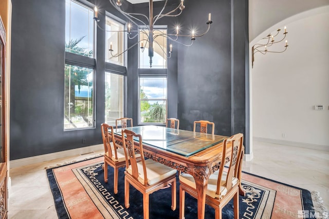 dining room with a towering ceiling and a notable chandelier