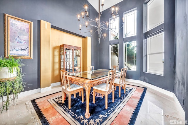 dining space featuring a high ceiling and a notable chandelier