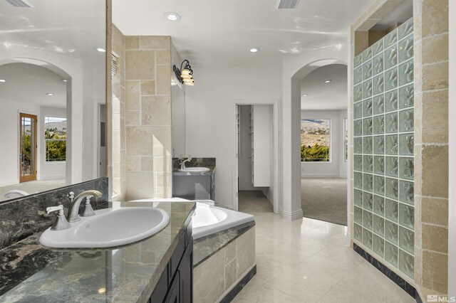 kitchen with a kitchen breakfast bar, dark stone countertops, built in refrigerator, dishwasher, and pendant lighting