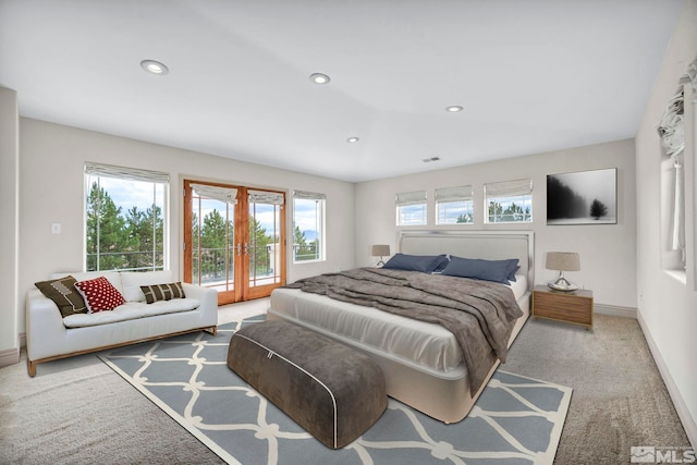 bedroom with multiple windows, light carpet, and french doors