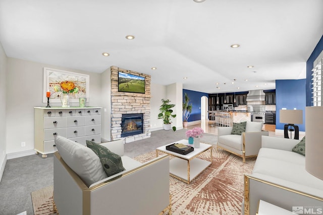 living room featuring light carpet and a stone fireplace