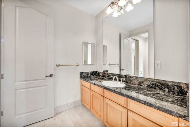 bathroom featuring an inviting chandelier, tile patterned flooring, and vanity