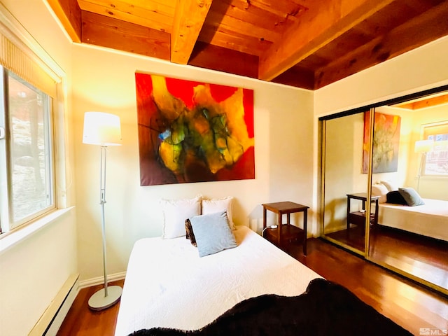 bedroom featuring beamed ceiling, wood ceiling, wood-type flooring, baseboard heating, and a closet