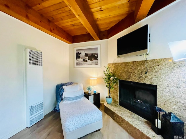 sitting room with a premium fireplace, beamed ceiling, wooden ceiling, and hardwood / wood-style floors