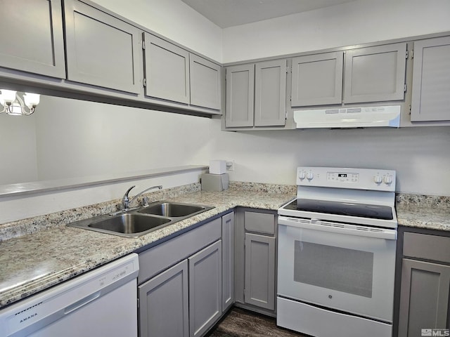 kitchen with dark hardwood / wood-style floors, extractor fan, gray cabinetry, sink, and white appliances