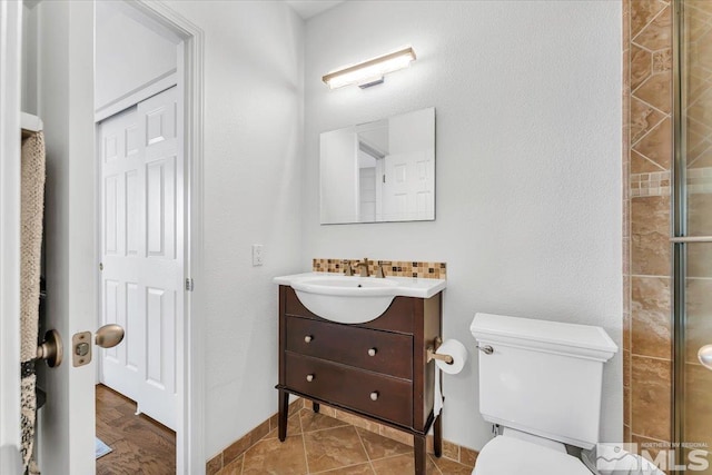 bathroom with tile patterned flooring, vanity, toilet, and a shower with door