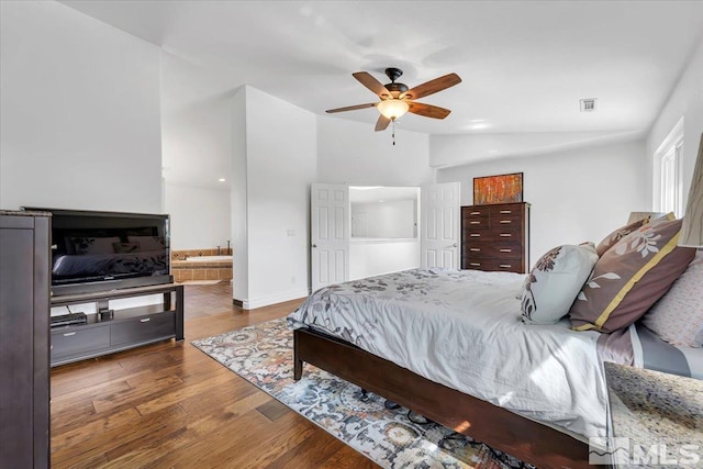 bedroom featuring vaulted ceiling, dark wood-type flooring, ceiling fan, and ensuite bathroom