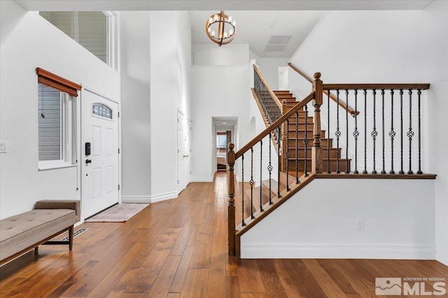 entryway featuring a notable chandelier, a towering ceiling, and hardwood / wood-style floors