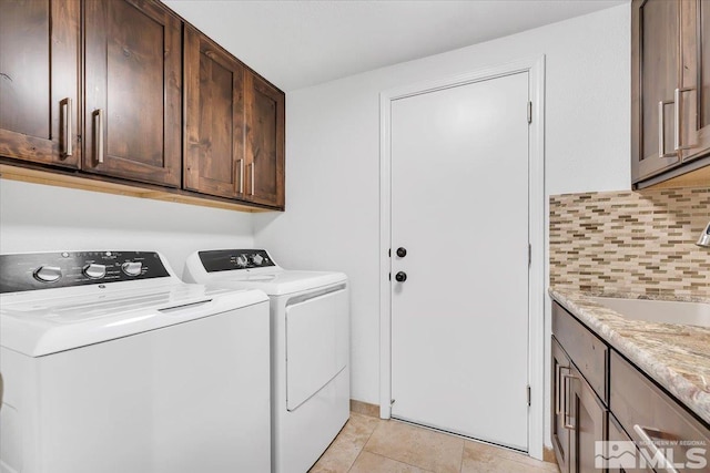 laundry area featuring cabinets, independent washer and dryer, light tile patterned flooring, and sink