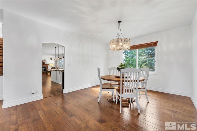 dining room with a notable chandelier and dark hardwood / wood-style floors