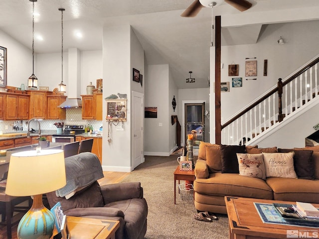 carpeted living room featuring a high ceiling and ceiling fan