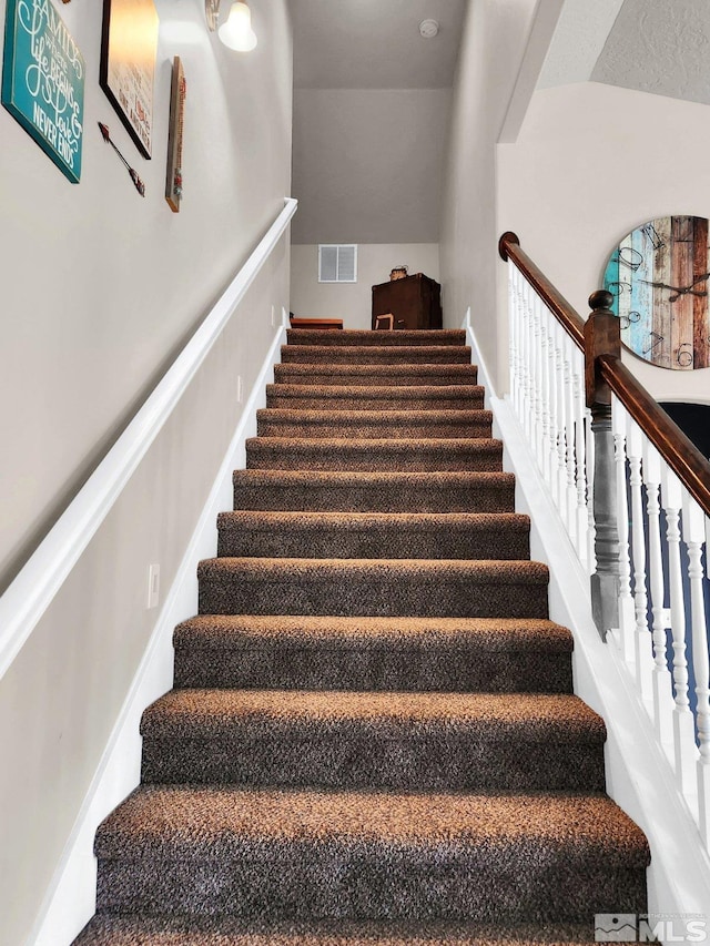 staircase featuring vaulted ceiling