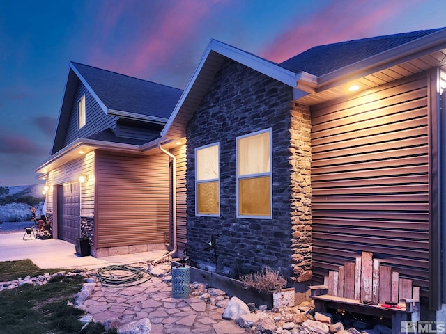 property exterior at dusk with a garage