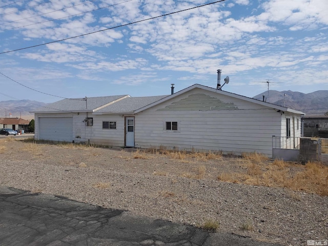 view of home's exterior with a mountain view and a garage