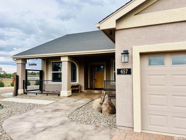 doorway to property featuring a porch and a garage