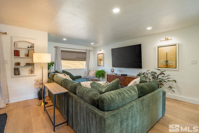 living room with built in features and light wood-type flooring