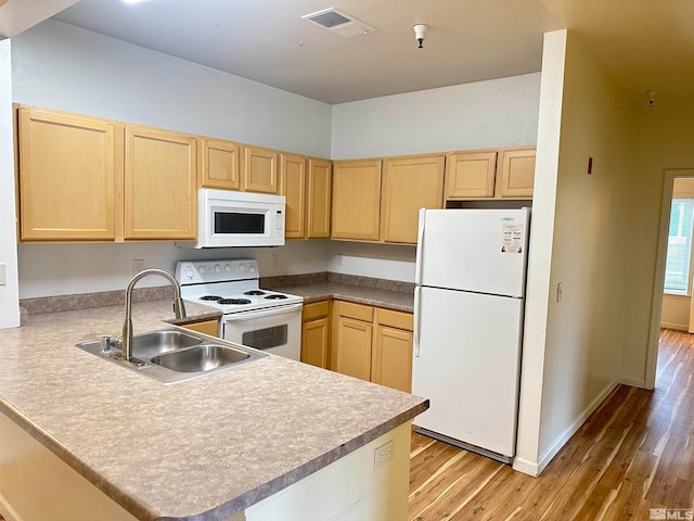 kitchen featuring sink, light hardwood / wood-style flooring, kitchen peninsula, white appliances, and light brown cabinetry