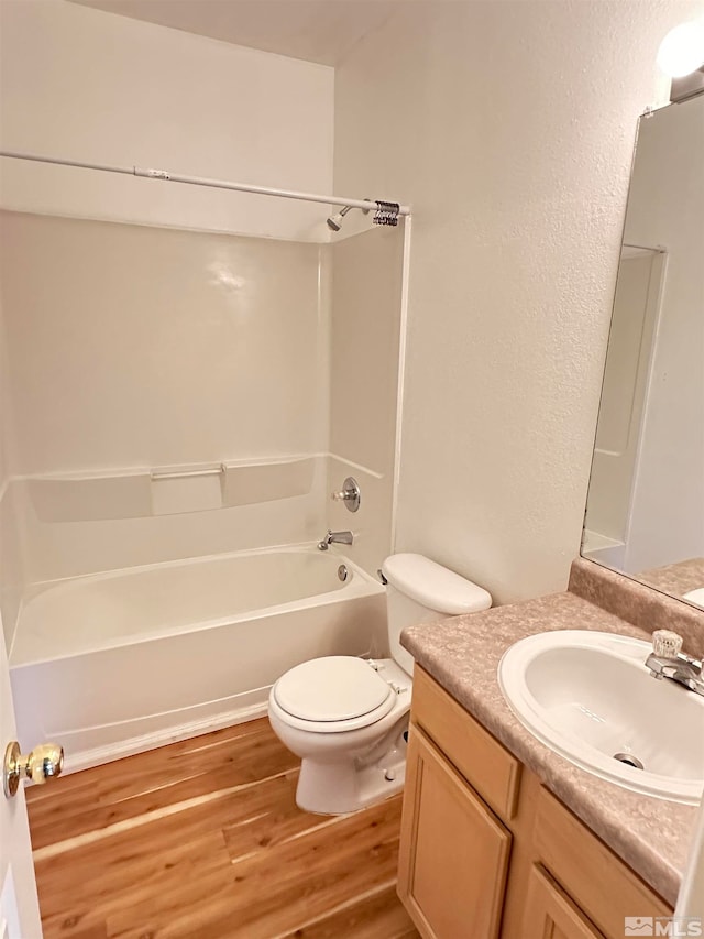 full bathroom with hardwood / wood-style floors, vanity, shower / bathtub combination, and toilet