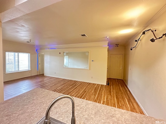 unfurnished living room featuring crown molding and light hardwood / wood-style floors