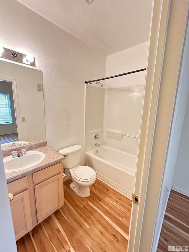 full bathroom featuring vanity, hardwood / wood-style flooring, toilet, and shower / bathtub combination