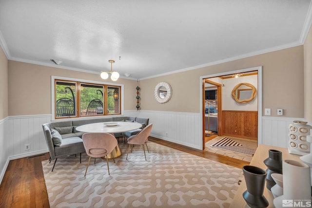 dining room featuring ornamental molding, a chandelier, and hardwood / wood-style flooring